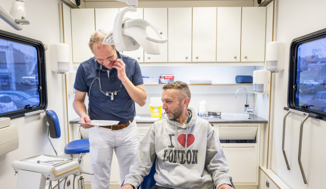 De rijdende tandartspraktijk bij een buurthuiskamer van het Leger des Heils