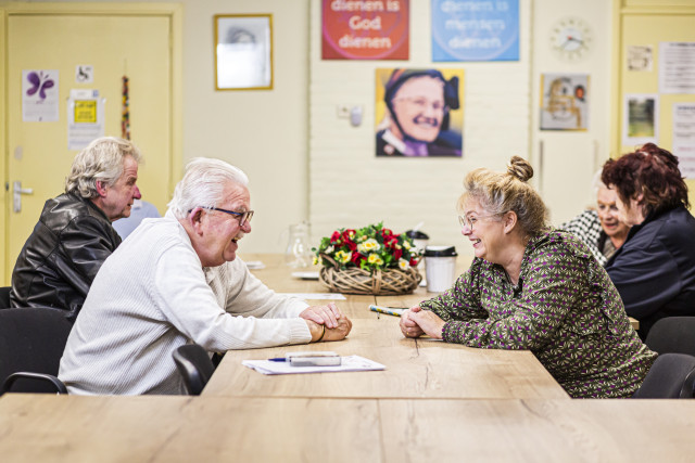 Esther in gesprek met bezoekers van de buurthuiskamer